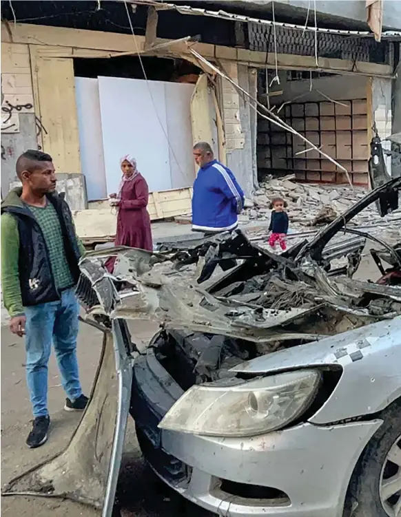  ?? Photo: AFP/Getty Images ?? People look at the car in which three sons of Hamas leader Ismail Haniyeh were killed in an Israeli air strike near Al Shati, northwest of Gaza City, on April 10.