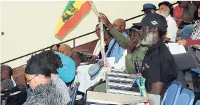  ?? PHOTOS BY MEL COOKE ?? An audience member holding a red, gold, and green flag during last Friday’s celebratio­n of His Imperial Majesty Haile Selassie’s 1966 visit to Jamaica, held at the Neville Hall Lecture theatre, UWI, Mona.