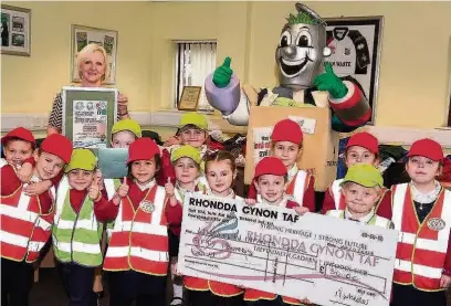  ??  ?? Proud pupils involved in the RCT-wide recycling challenge with Ann Crimmings and mascot Rhys Cycle