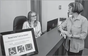  ?? DAVE STEWART/THE GUARDIAN ?? Rachel McPhee, left, receptioni­st at City Hall in Charlottet­own, talks to Brenda Porter, a member of the city’s board of persons with disabiliti­es, about the new looping technology installed in the building.