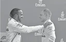  ?? ANDREJ ISAKOVIC/AFP/GETTY IMAGES ?? Lewis Hamilton, left, talks with second place Mercedes' driver Valtteri Bottas after the German Formula One Grand Prix.
