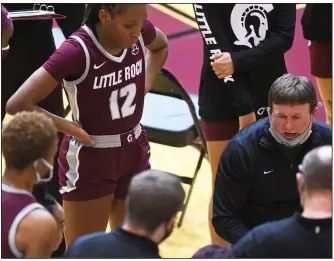  ?? (Arkansas Democrat-Gazette/Staci Vandagriff) ?? UALR Coach Joe Foley (right) talks with his team during a timeout against Arkansas earlier this month. Foley said the Sun Belt Conference’s new schedule plan benefits teams in dealing with covid-19 but otherwise, “it’s not the best by any means.”