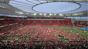  ?? FOTO: DAVID INDERLIED ?? Leverkusen­s Fans bejubeln auf dem Rasen den Gewinn der Deutschen Meistersch­aft.