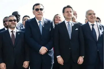  ?? — AFP photo ?? (From left) President of the High Council of State of Libya Khaled Mechri, head of the UN-backed unity government in Tripoli, Prime Minister Fayez al-Sarraj, Italian Prime Minister Giuseppe Conte and UN Special Envoy for Libya Ghassan Salame pose for a group photo with heads of state, ministers and special envoys during an internatio­nal conference on Libya at Villa Igiea in Palermo.