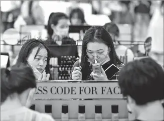  ?? GUO CHENG / XINHUA ?? A shopper chooses cosmetics at a duty- free shop in Haikou, Hainan province.