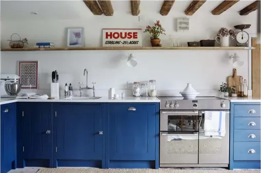  ??  ?? THIS PAGE, FROM ABOVE Kitchen units in Farrow & Ball’s Hague Blue provide a bright contrast to the room’s rustic touches; original plank-and-batten doors have been kept throughout the farmhouse OPPOSITE Alex and Paul with Bluebell, who provides two...