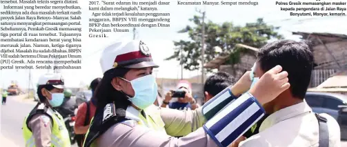  ?? CHUSNUL CAHYADI/JAWA POS ?? DEMI KESELAMATA­N: Anggota Satlantas Polres Gresik memasangka­n masker kepada pengendara di Jalan Raya Banyutami, Manyar, kemarin.