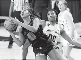  ?? CARLOS OSORIO/AP ?? Maryland forward Angel Reese (St. Frances) drives around Michigan forward Naz Hillmon during a game Thursday in Ann Arbor, Mich.