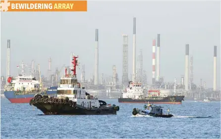  ?? — Reuters ?? Boats sail past Pulau Bukom oil refinery along the southern coast of Singapore.