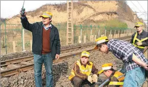  ?? PROVIDED TO CHINA DAILY ?? Yang Jingxing (left) and his colleagues work on repairing a section of railway in Shaanxi province last year.