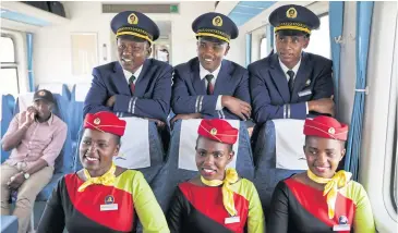  ?? EPA ?? Kenya Railways train attendants pose for a photograph inside one of the new passenger trains using the new Mombasa to Nairobi Standard Gauge Railway (SGR) during a test run on Monday.