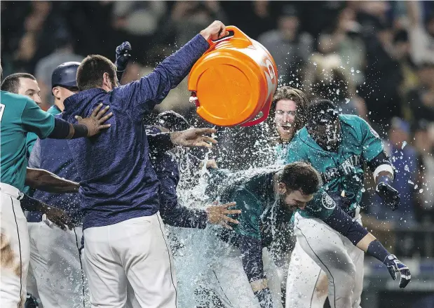  ?? — GETTY IMAGES FILES ?? Mitch Haniger is doused with Gatorade after hitting a walk-off home run in the bottom of the 13th inning to give Seattle a 4-3 win over the Tampa Bay Rays on Friday night at Safeco Field. The surprising Mariners are 6-0 in extra-inning games this season.