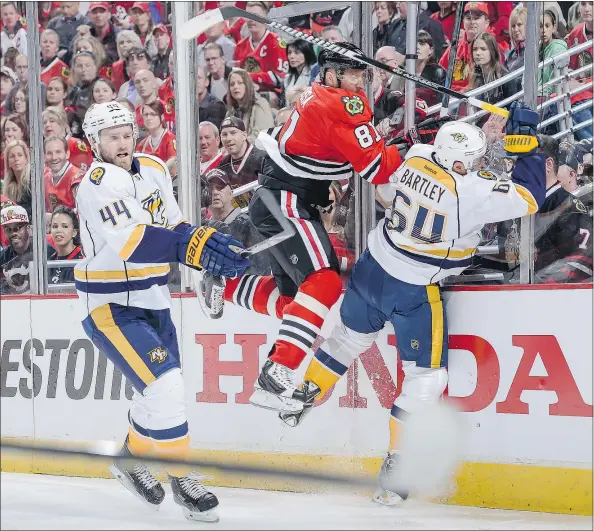  ?? — GETTY IMAGES FILES ?? Cody Franson, left, and Predators teammate Victor Bartley give Chicago’s Marian Hossa a rough ride in the playoffs. Franson, a 27-year-old defenceman, is one of the most intriguing free agents this summer, especially where the Canucks are concerned.