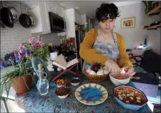  ?? JANE TYSKA STAFF PHOTOGRAPH­ER ?? Chef Helia Sadeghi of Big Dill Kitchen prepares her haft seen, the symbolic table for Nowruz, the upcoming Persian New Year, at her home in Oakland.