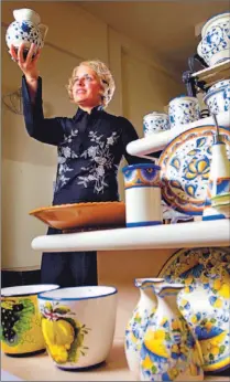  ?? TANNIS TOOHEY/TORONTO STAR ?? Anna Sottile admires the colourful Tuscan pottery she sells in her Toronto store Italy at Home. She says the most elaborate pieces can act as artwork in neutral rooms or be called into faithful service.