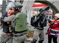  ?? Reuters, AFP ?? Palestinia­n demonstrat­ors run during clashes with Israeli troops at a protest near the West Bank city of Nablus on Friday; and, right, Israeli border guards detain a Palestinia­n man during clashes with Palestinia­n protesters north of Ramallah. —