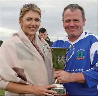  ??  ?? Darragh Kelly, captain of Taghmon United, receives the Richie Dwyer Memorial Cup from Sami Sinnott, daughter of the late Richie.