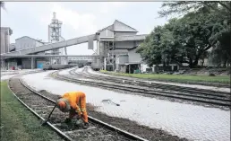  ??  ?? A worker clears debris from railway tracks at the PPC cement plant in Pretoria. South Africa’s largest cement maker sees a pick-up in demand in its home market as President Cyril Ramaphosa inspires greater investor confidence.