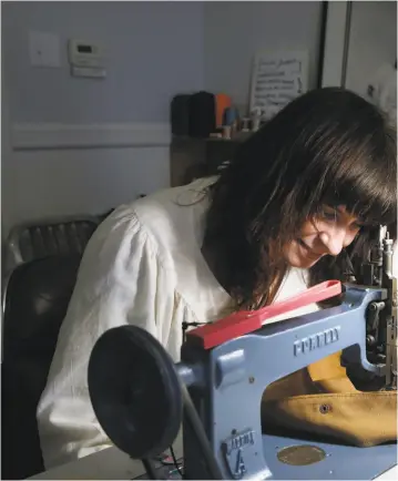  ??  ?? Top: Isabella Hill embroiders a design on a jacket at her home in San Francisco. Hill is a preschool teacher who has turned to her clothing design skills to make ends meet during the coronaviru­s pandemic.