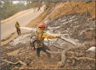  ?? (The New York Times/Daniel Dreifuss) ?? Firefighte­rs put out a hot spot Thursday in the Sequoia National Forest in central California, where a wildfire is only 12% contained, officials said.