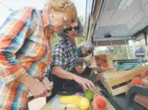  ?? Kathryn Scott, Special to The Denver Post ?? Shelley Cook, second from left, sells some of her produce to Barbara Sloan, left, and Doris Buckley earlier this month in Arvada. Cook was taking the Veggie Van on a delivery route.