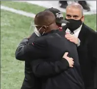  ?? The Associated Press ?? COACHING CAROUSEL: Atlanta Falcons head coach Raheem Morris, left, and Las Vegas Raiders head coach Jon Gruden greet each other with a hug after the Falcons defeated the Raiders in a Nov. 29 game in Atlanta.
