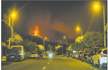  ?? Jonathan Rodriguez The Associated Press ?? Lava flows early Monday from an eruption of a volcano near El Paso on the island of La Palma in the Canaries, Spain. The lava destroyed more than 100 homes on the hillsides.