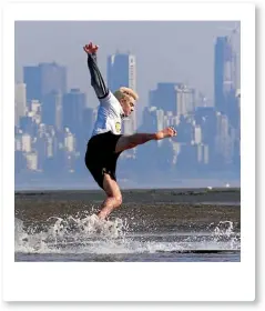  ?? REUTERS ?? A skim boarder loses his balance while out enjoying summer weather during low tide along a Vancouver beach.