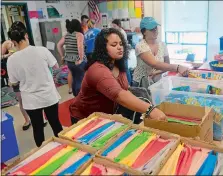  ?? SARAH GORDON THE DAY ?? Norwich Free Academy senior Aleysha RiveraBoca­chica, center, and other volunteers with the school’s Project Outreach Program, fill backpacks on Monday.