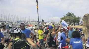  ??  ?? L’équipe de l’Echappée bleue qui organise le raid distribue le de Porqueroll­es. road-book à chacune des équipes sur le port