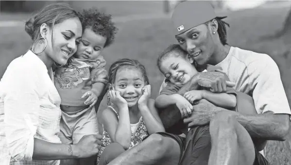  ?? THE ENQUIRER/JEFF SWINGER ?? Chris Henry, right, poses along with, from left, his fiance Loleini, and their kids Demarcus, 10 months, Seini, 3, and Chris Jr., 2, at their home in September 2009.