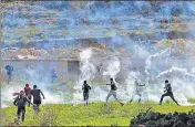  ?? ?? Palestinia­ns run for cover during clashes with Israeli security forces in Beit Eil, in the occupied West Bank, on Monday.