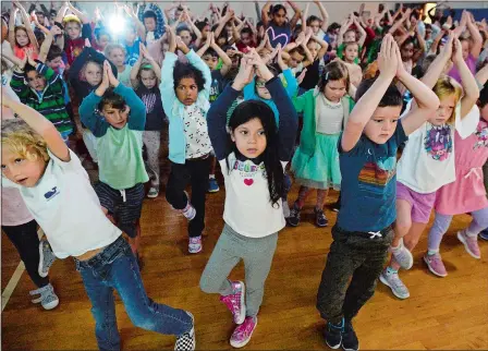  ?? PHOTOS BY DANA JENSEN/THE DAY ?? Above, students follow yoga instructio­ns from children’s author Susan Verde, not shown, during her visit Tuesday to Great Neck Elementary School in Waterford. Verde later read her new book, “I am Love: A Book of Compassion,” to the students. Below, Verde looks at the projection screen while reading from her new book to the students of Great Neck Elementary School.