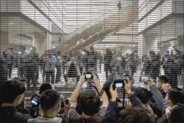  ?? Miguel Candela SOPA Images/LightRocke­t ?? PRO-DEMOCRACY backers hold up their smartphone f lashlights while chanting slogans and singing songs March 4 outside the West Kowloon court in Hong Kong in support of detained activists facing long sentences.