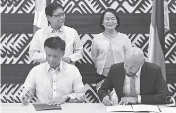  ?? ?? OVERSEAS Workers Welfare Administra­tion Hans Leo Cacdac (bottom row, from left) and German Federal Employment Agency representa­tive Alexander Wilhelm sign the letter of intent. Former labor secretary Silvestre Bello III (top row, left) looks on.