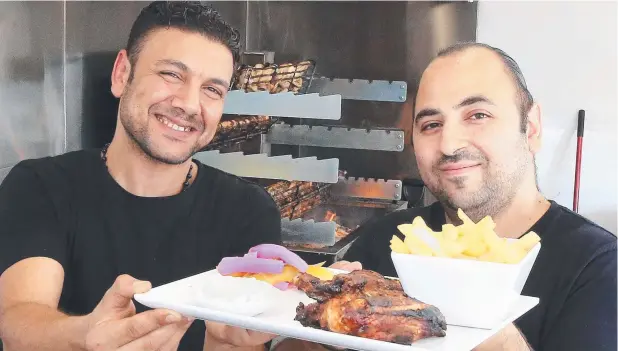  ?? Picture: JUSTIN BRIERTY ?? TASTY TREAT: Chef Sam Allam and owner Mark Meade at Finger Lickin Charcoal Chicken on Mulgrave Rd.