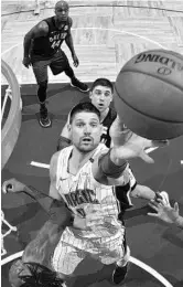  ?? FERNANDO MEDINA/GETTY ?? Nikola Vucevic tips the ball in during a recent Magic game against the Nets. Denver forward Paul Millsap contended that his teammate, Nikola Jokic, is better than Vucevic.