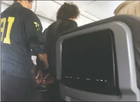  ?? DONNA BASDEN via AP ?? In this photo provided by Donna Basden, a man is escorted off an American Airlines flight Friday after it landed in Honolulu.