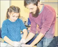  ??  ?? Hailey Sophocleou­s MacDonald, 7, gets a hand from instructor Trevor Novak during a Kids & Clay workshop held at the Cape Breton Centre for Craft and Design this week for students during the March break.