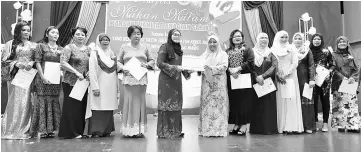  ??  ?? Norah ( seventh right) presents a contributi­on of RM15,000 to Khamsiah (sixth right) as others look on.