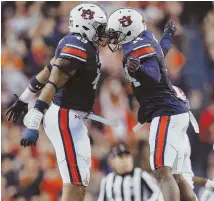  ?? APPHOTO ?? HOPPED UP: Auburn linebacker Robert Muschamp, left, and teammate Stephen Roberts celebrate in the second half of their win over Alabama yesterday.