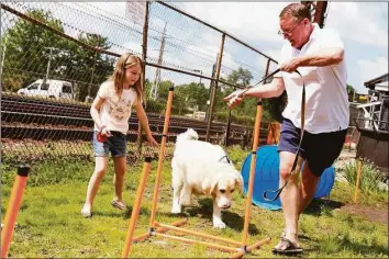  ?? Jarret Liotta / Hearst Connecticu­t Media / Connecticu­t Post ?? Charlie Hannigan of Darien and his niece, Maeve, 6, put their dog Brody through his paces at The Darien Depot’s Dog Show on May 23, 2021.