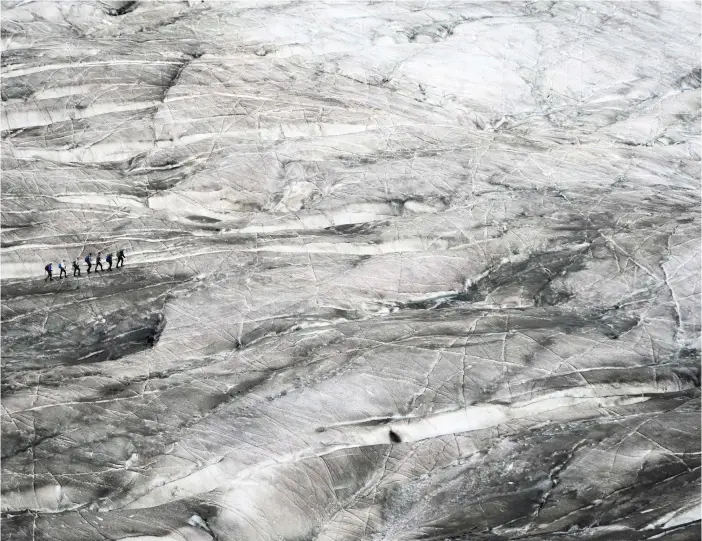  ?? FOTO: LAURENT GILLIERON/KEYSTONE VIA AP/TT, ARKIVBILD ?? En grupp vandrare korsar Aletschgla­ciären, en glaciär som krymper allt mer.