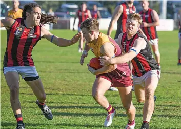 ?? ?? Drouin’s Will Papley (centre) looks to break through the pressure of Maffra’s Brodie Tahara (left) and James Read.