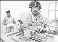  ??  ?? An Iraqi army commando casts his ballot for the provincial elections at a polling station in the southern city of Basra on April 13. Iraqi soldiers and policemen cast their ballots for provincial elections, a week ahead of the main vote that
comes...