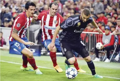  ??  ?? MADRID: Real Madrid’s French forward Karim Benzema (R) vies with Atletico Madrid’s Uruguayan defender Diego Godin (C) and Atletico Madrid’s Montenegri­n defender Stefan Savic during the UEFA Champions League semifinal second leg football match Club...