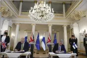  ?? FRANK AUGSTEIN — THE ASSOCIATED PRESS ?? British Prime Minister Boris Johnson, left, and Finland's President Sauli Niinisto sign a security assurance at the Presidenti­al Palace in Helsinki, Finland, on Wednesday.