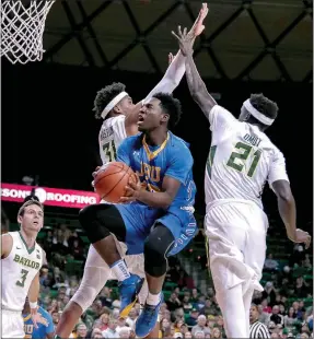  ?? Photo courtesy of JBU Sports Informatio­n ?? John Brown’s Marquis Waller slices through traffic in an exhibition game against Baylor last season. Waller, a junior, is expected to be a key player for the Golden Eagles in 2017-18.