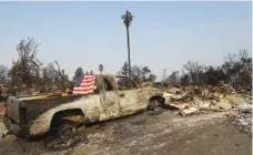  ?? THE ASSOCIATED PRESS ?? A flag is draped on the back of a truck destroyed by fires in Santa Rosa, Calif., on Wednesday.