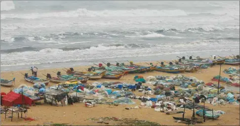  ??  ?? Boats are seen parked on deserted Marina beach during rains before Cyclone Nivar’s landfall, in Chennai yesterday.